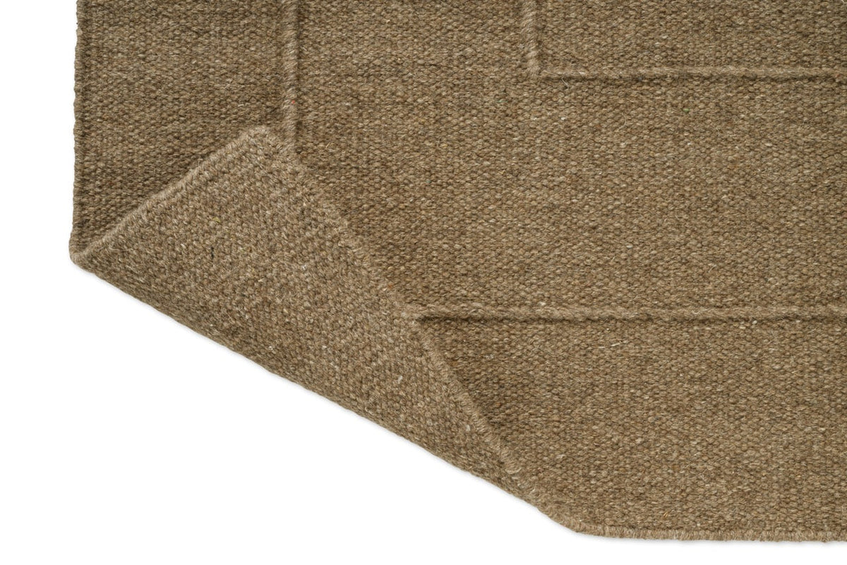 Brink & Campman Senso Border Fur Brown Teppich, Detail von umgeschlagener Ecke und Rückseite