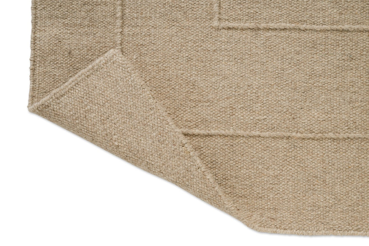 Brink & Campman Senso Border Natural Teppich, Detail von umgeschlagener Ecke und Rückseite