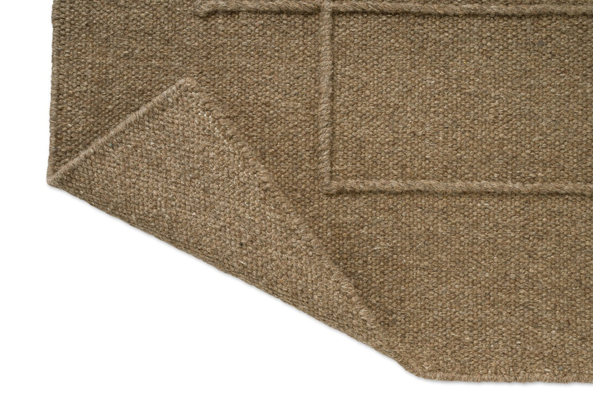 Brink & Campman Senso Level Fur Brown Teppich, Detail von umgeschlagener Ecke und Rückseite