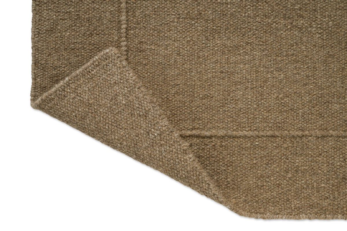 Brink & Campman Senso Planes Fur Brown Teppich, Detail von umgeschlagener Ecke und Rückseite