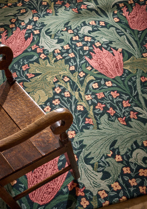 Morris & Co Lent Lily Indigo Madder Teppich in Indigo mit krapproten Tulpen und salbeigrünen Blättern, im Wohnraum, zweite Ansicht