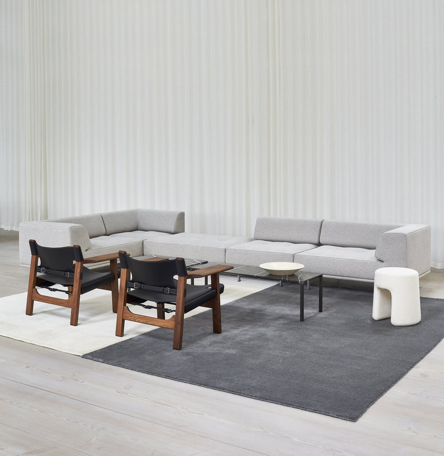 Massimo Earth Natural Dark Grey Wollteppich, in einem hellen Raum